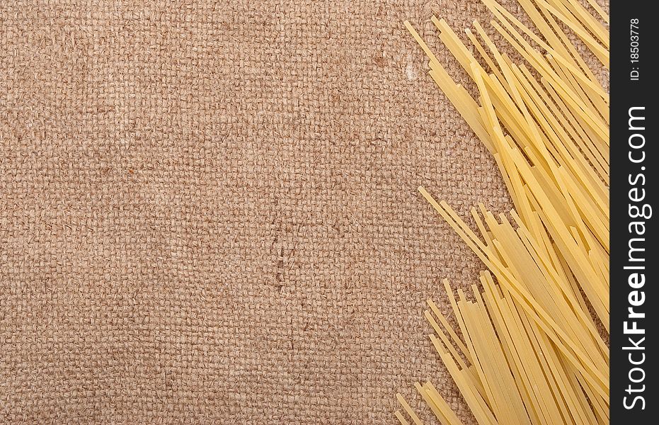 Raw spaghetti on the burlap background