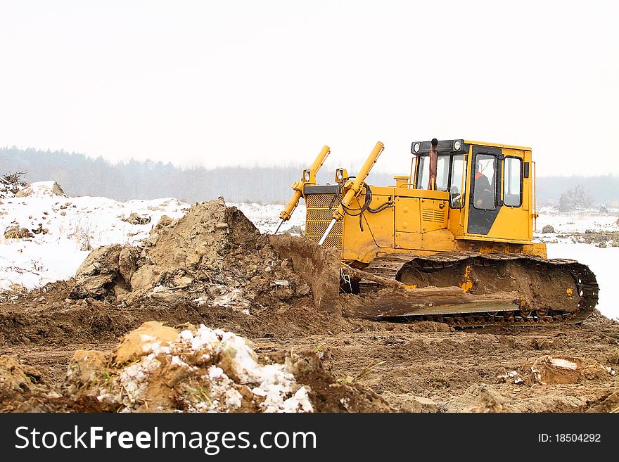 Bulldozer loader at winter frozen soil excavation works. Bulldozer loader at winter frozen soil excavation works