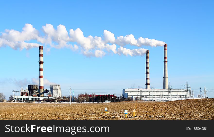 Smoking chimneys power against the blue sky. Smoking chimneys power against the blue sky