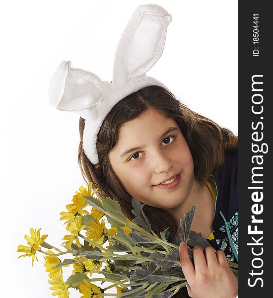 Closeup portrait of an attractive preteen girl in bunny ears while holding a bouquet of yellow flowers. Isolated on white. Closeup portrait of an attractive preteen girl in bunny ears while holding a bouquet of yellow flowers. Isolated on white.