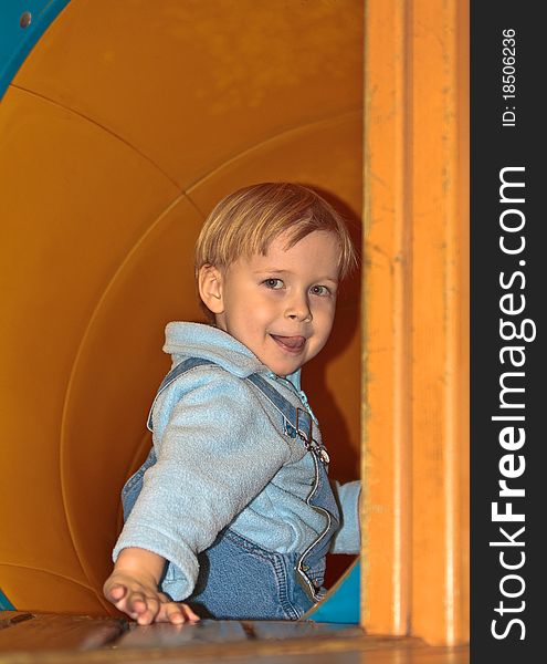 Caucasian blond boy in a tube slide. Caucasian blond boy in a tube slide