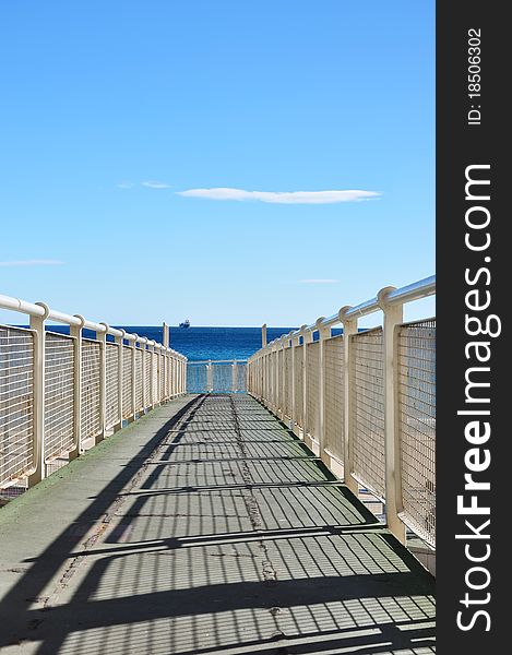 Iron pier to coast of Alicante with cargo ship, Spain