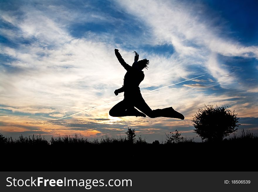 Jumping woman in nature over beautiful sunset symbolizing freedom and pleasure from life. Jumping woman in nature over beautiful sunset symbolizing freedom and pleasure from life