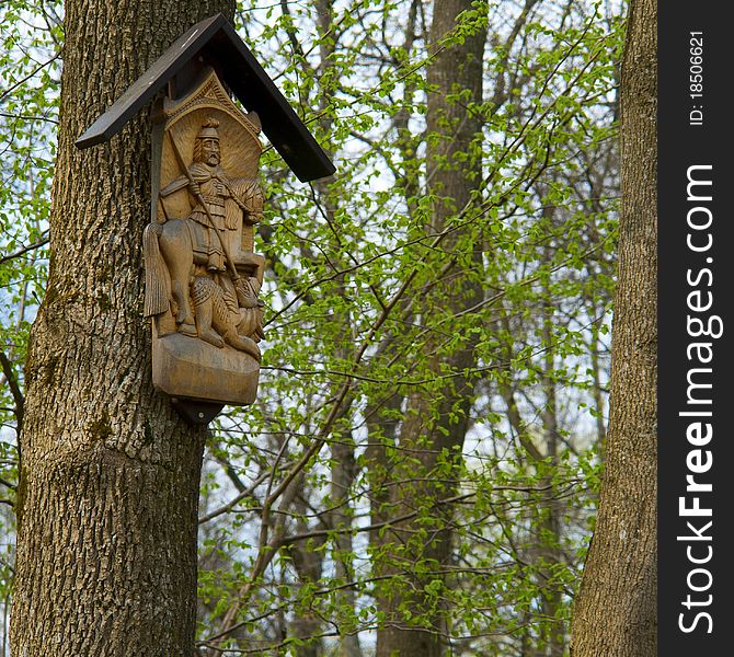 Wooden sculpture is installed on a tree in the forest. Wooden sculpture is installed on a tree in the forest