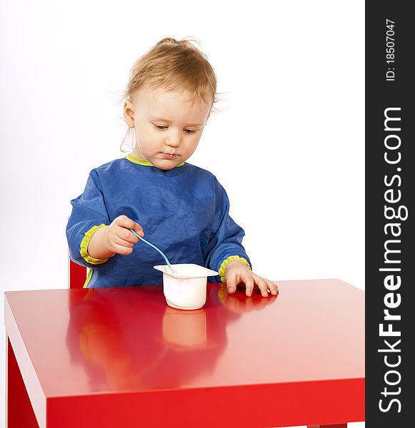 Little Baby Is Eating On Red Table