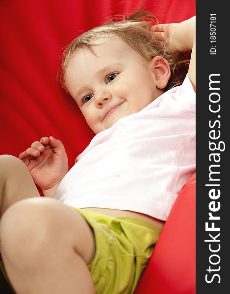 Little Baby On Red Background In Studio