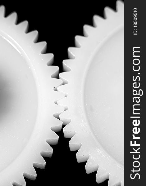 Two white connected cogwheels on black background. Two white connected cogwheels on black background