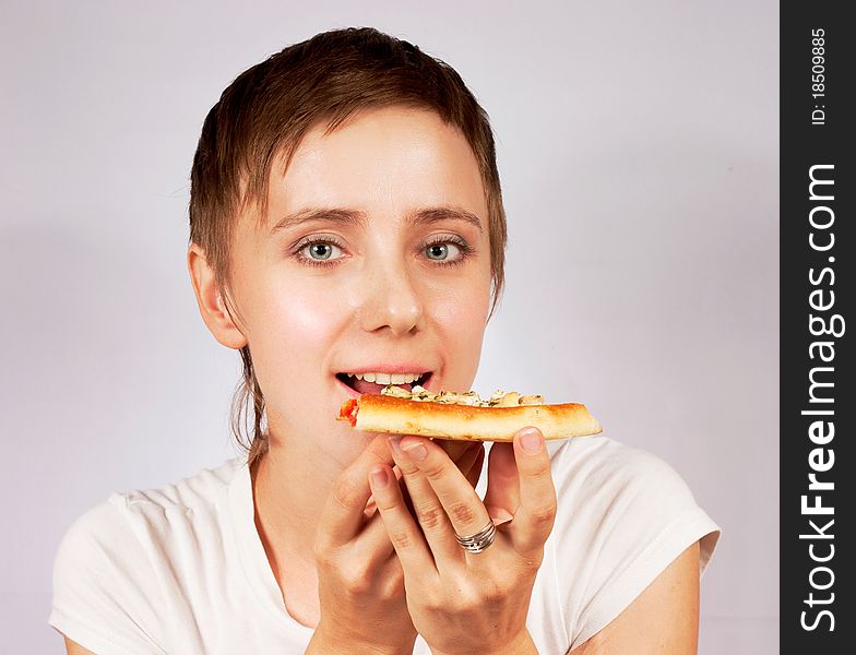 Young woman eating pizza on gray backgrounde. Young woman eating pizza on gray backgrounde