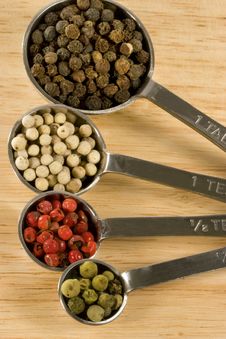 Peppercorns In Spoons Stock Images
