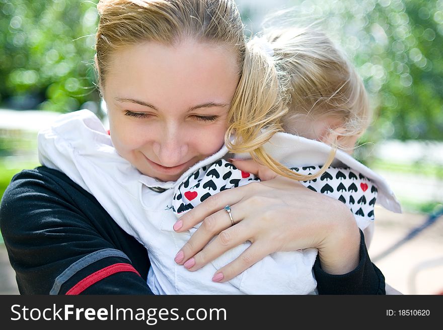 Mama hugs her daughter and smiles of happiness. Mama hugs her daughter and smiles of happiness