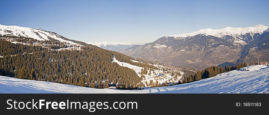 Panoramic view of a snow covered mountain range looking down valley. Panoramic view of a snow covered mountain range looking down valley