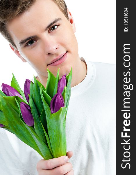 Handsome young man with a bouquet of tulips