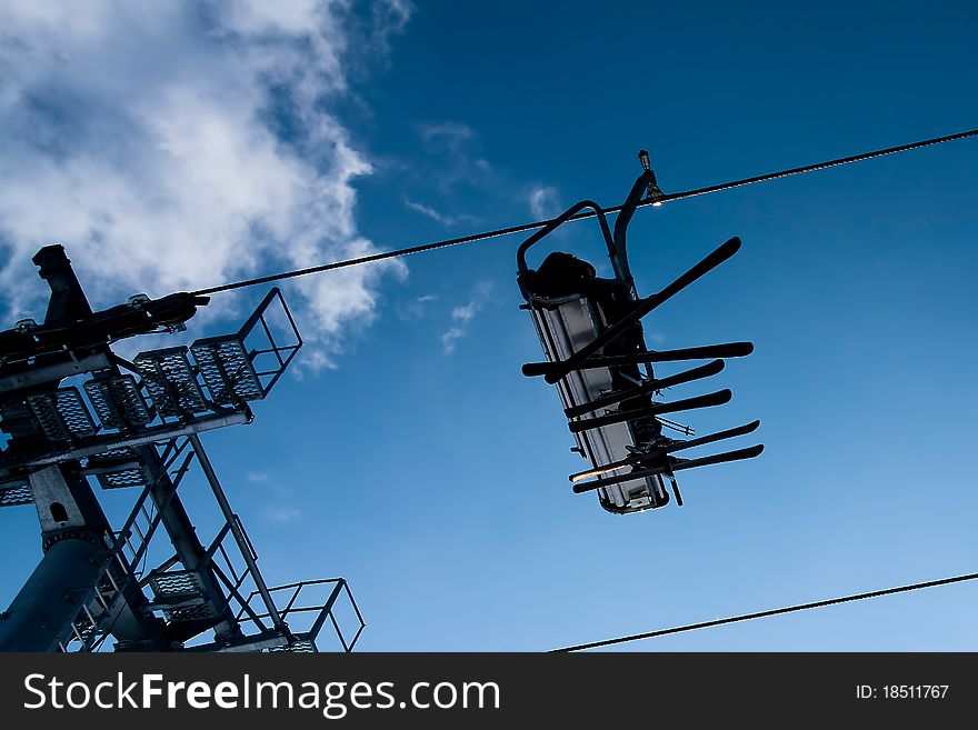 Chairlift with three people (blue sky)