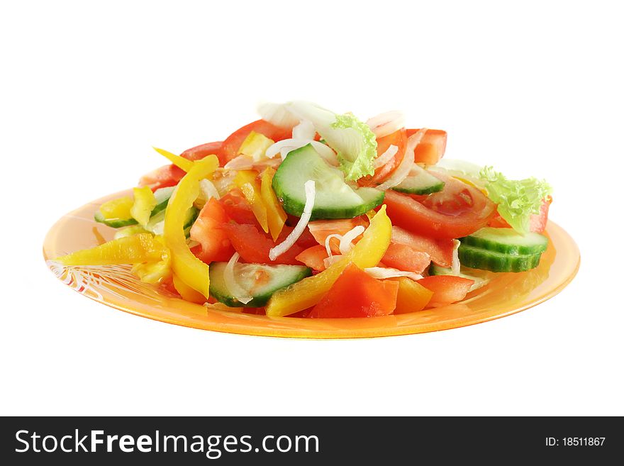 Salad made up of fresh cutted vegetables (tomato, cucumber, onion, sweet pepper and leaf lettuce), in orange glass plate, isolated on white. Salad made up of fresh cutted vegetables (tomato, cucumber, onion, sweet pepper and leaf lettuce), in orange glass plate, isolated on white