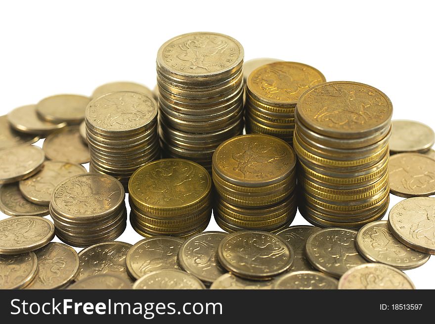 Coins in piles and loose on a white background