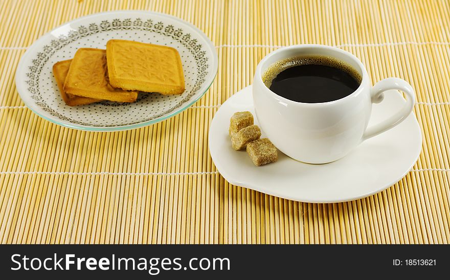 Cup of coffee and biscuits on a plate stand on a napkin reed. Cup of coffee and biscuits on a plate stand on a napkin reed