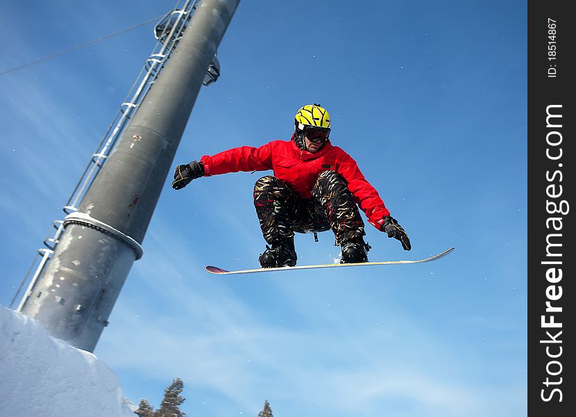 Snowboarder jumping through air with deep blue sky in background