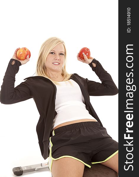 A woman is on a weight bench lifting apples. A woman is on a weight bench lifting apples.