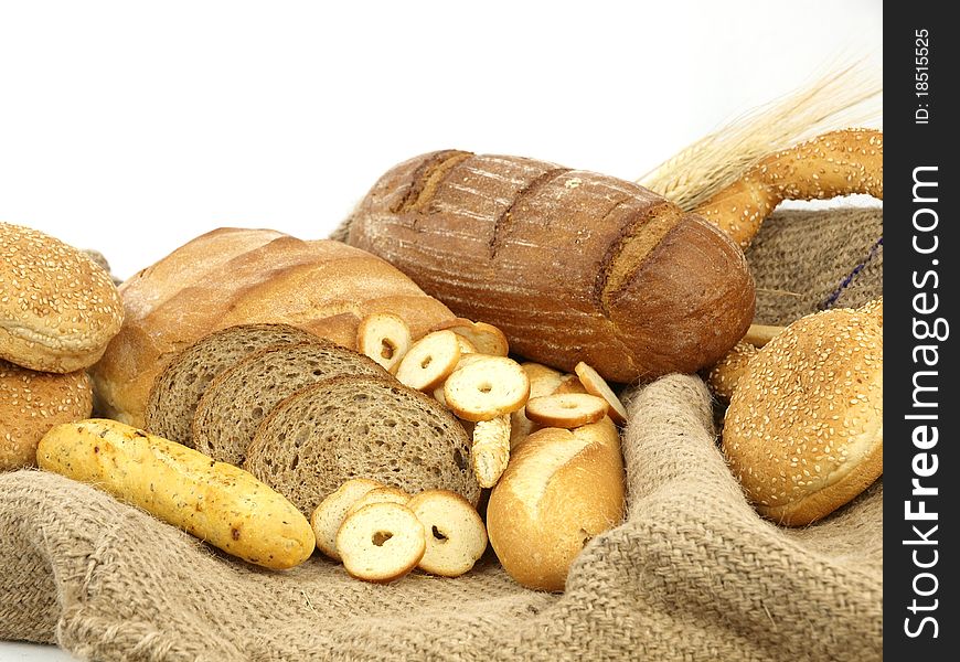 Various types of bread and other wheat products in a burlap background