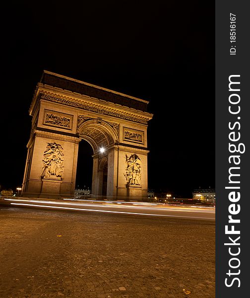 A shot of a the Arc de Triomphe in Paris at night.