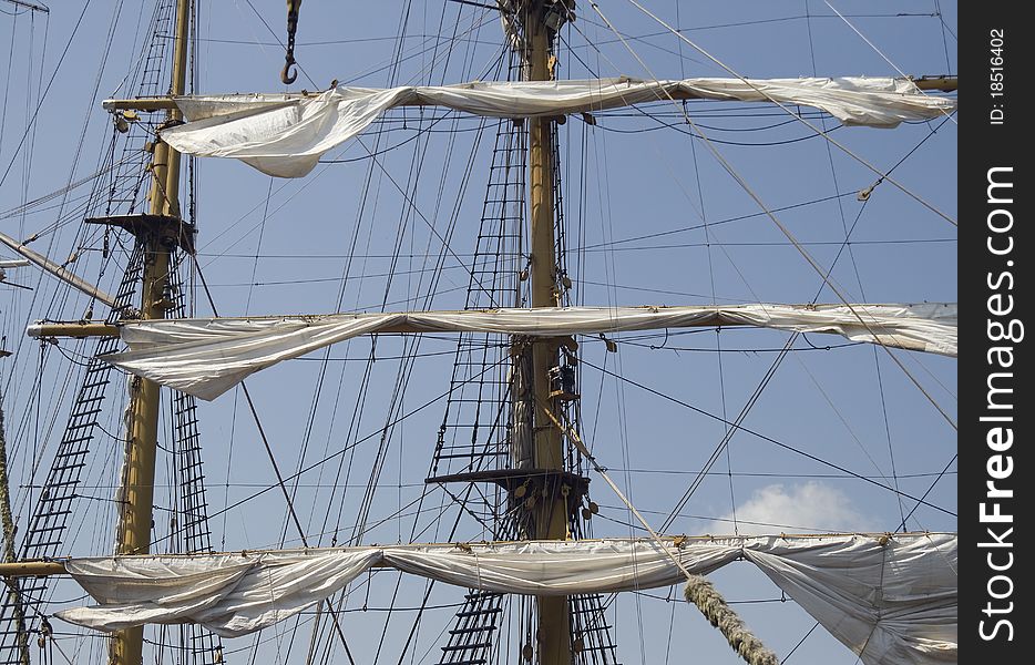 Mast of a tall ship with half-hoisted sails