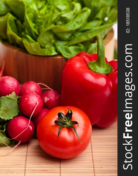 Different ripe vegetables composition in studio laying on bamboo plate