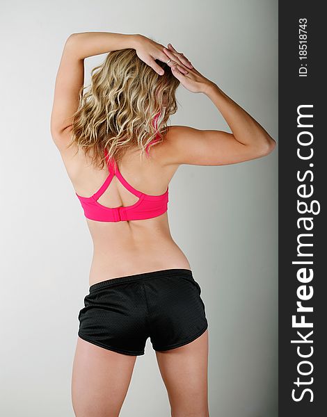 Young woman wearing fitness outfit shows off her backside. Young woman wearing fitness outfit shows off her backside.