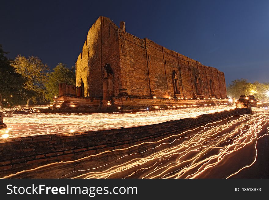 Candle light trail of Buddhism Ceremony at temple ruin at dusk on Asalha Puja day