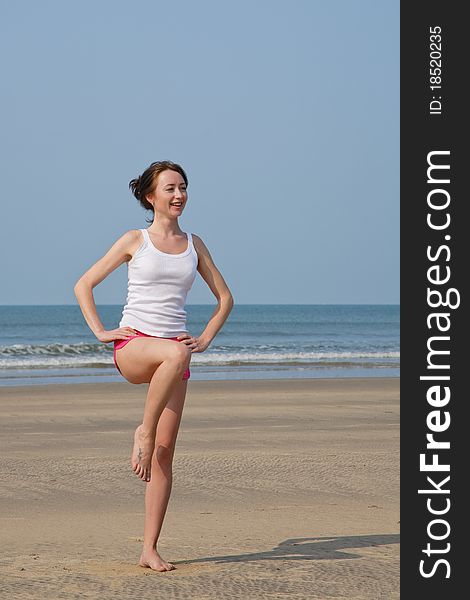 Young Woman Doing Exercises On The Beach