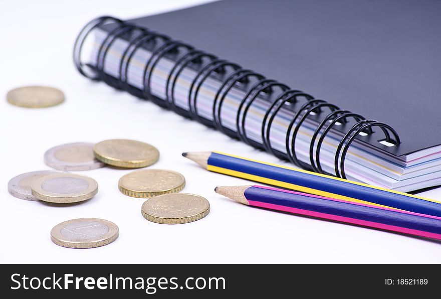 Notebook with pencils and coins