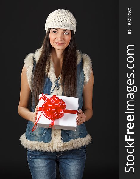 Portrait of young female in the knitted cap holding gift box. Portrait of young female in the knitted cap holding gift box