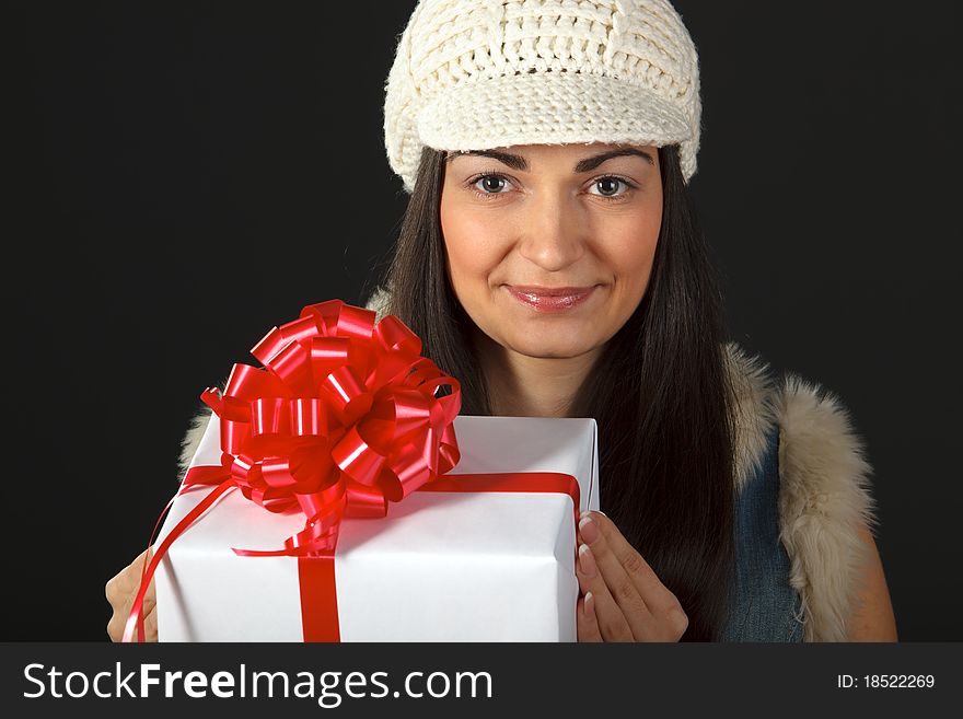 Portrait of young female in the knitted cap holding gift box. Portrait of young female in the knitted cap holding gift box