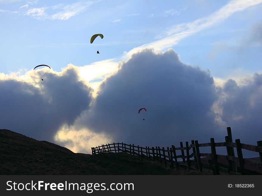 Three paragliders floating around mam tor. Three paragliders floating around mam tor