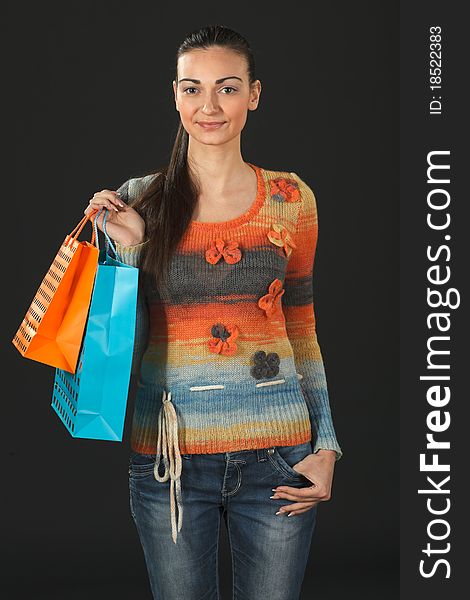 Young elegant female in sweater holding paper-bags with purchases. Young elegant female in sweater holding paper-bags with purchases
