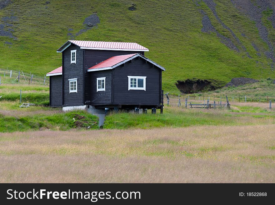 Black wooden house with white windows in Iceland