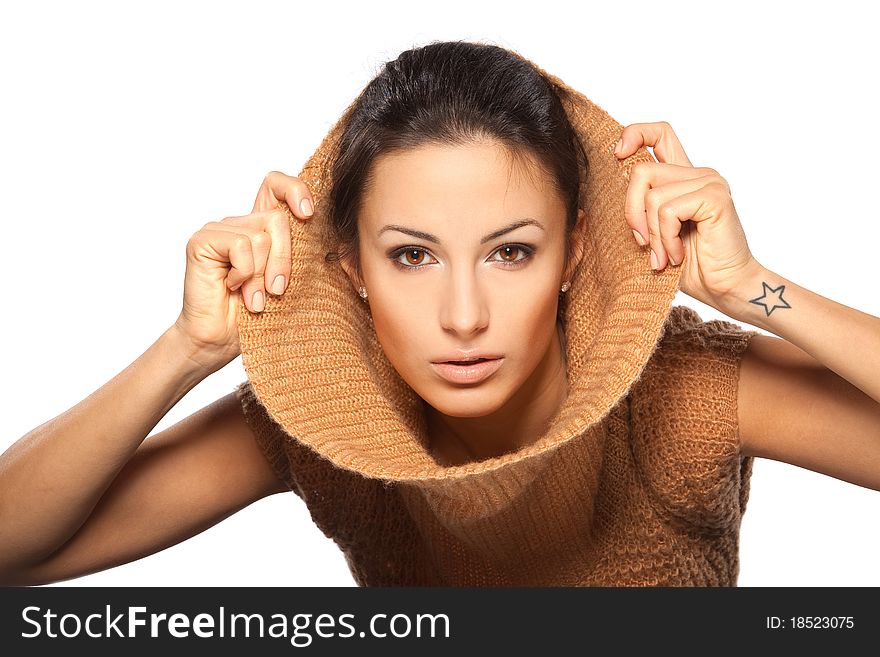 Studio portrait of young attractive brunette female slipping her sweater collar on, isolated on white. Studio portrait of young attractive brunette female slipping her sweater collar on, isolated on white