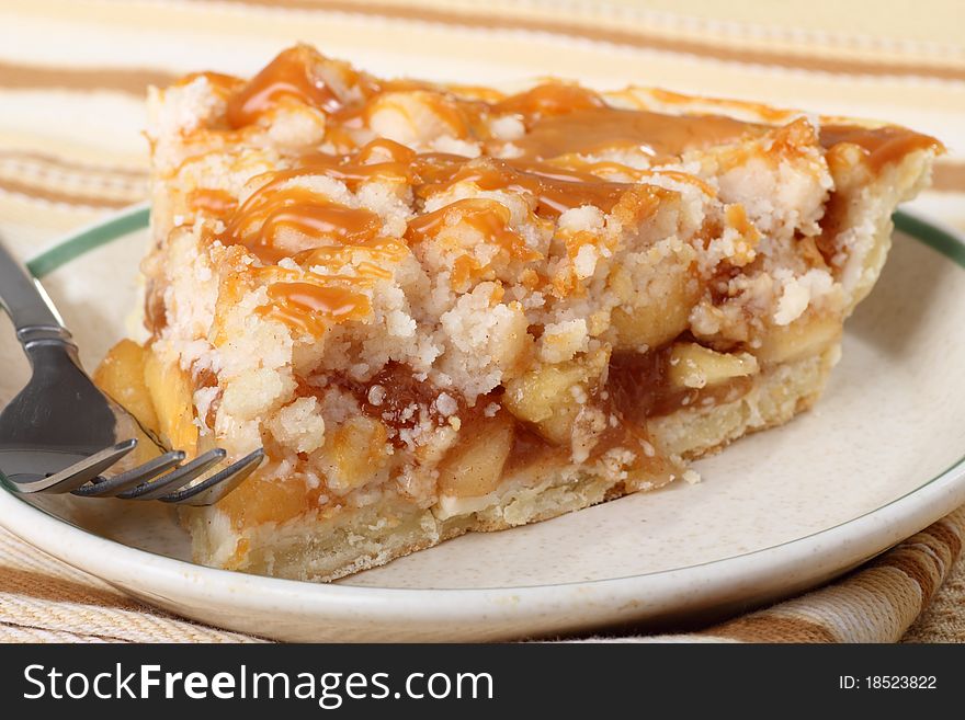 Slice of apple pie topped with caramel