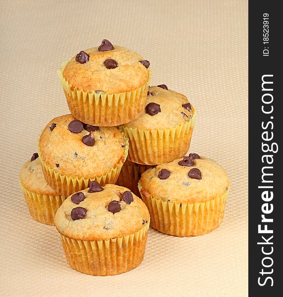 Stack of chocolate chip muffins on a brown background