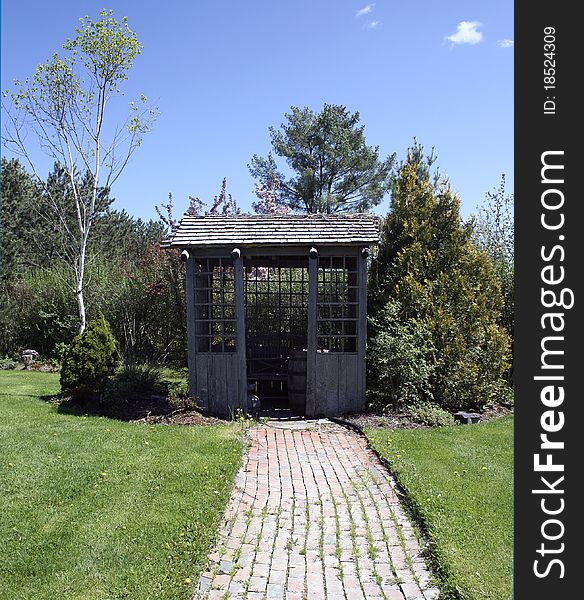 Garden shed with brick path leading in green grass. Garden shed with brick path leading in green grass