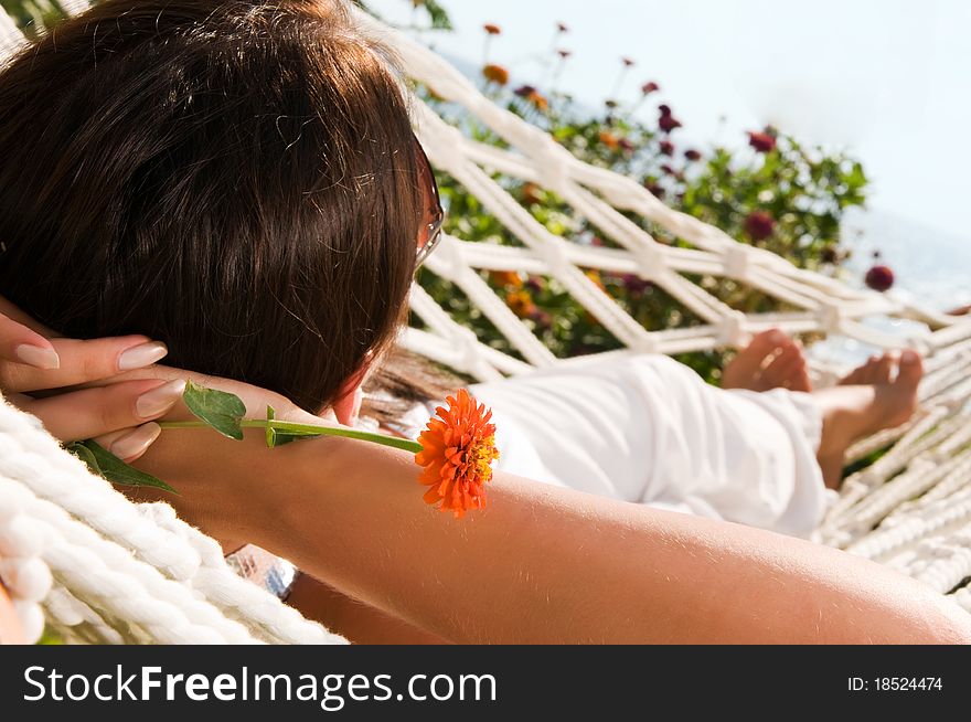 Young woman in hammock, focus on the flower (shallow dof)