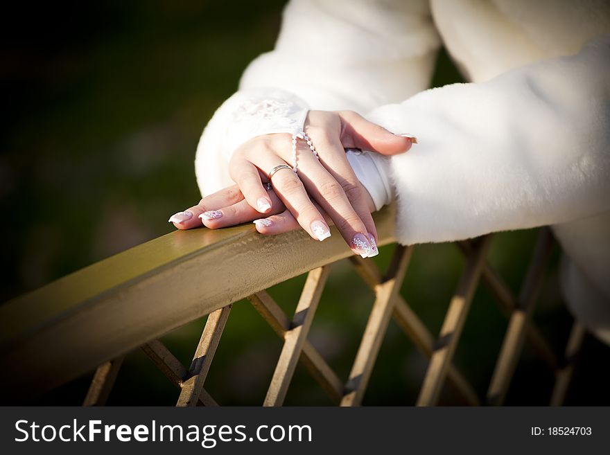 Gentle hands of the bride in a fur coat with a wedding ring