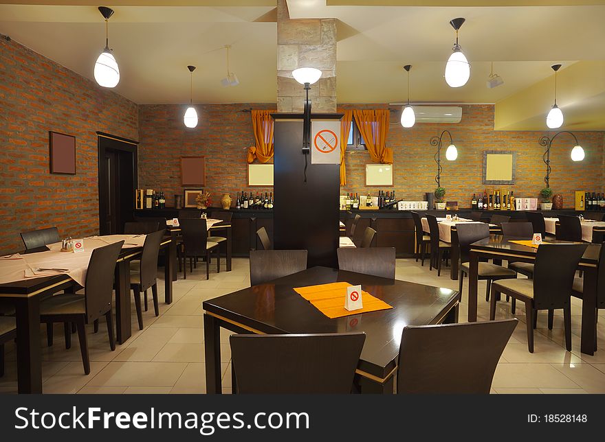 Tables, chairs, brick wall and lighting equipment of a restaurant. Tables, chairs, brick wall and lighting equipment of a restaurant.