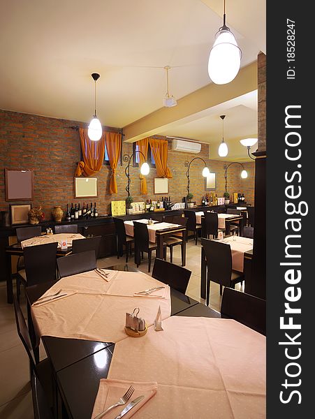 Tables, chairs, brick wall and lighting equipment of a restaurant. Tables, chairs, brick wall and lighting equipment of a restaurant.