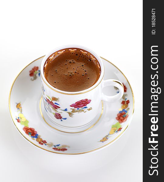 A cup of greek coffee in a traditional porcelain set. A cup of greek coffee in a traditional porcelain set