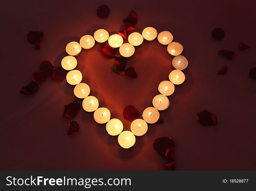 Heart of candles with rose petals. Heart of candles with rose petals