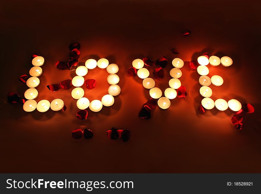 Letters of candles with rose petals. Letters of candles with rose petals