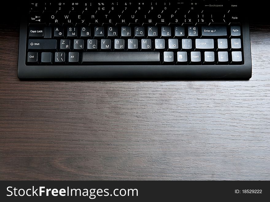 Single black keyboard on dark desk. Single black keyboard on dark desk.