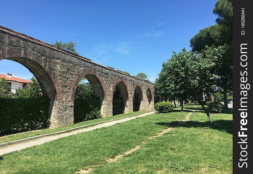 The weather is good, take a walk near home, passing a row of stone gate walls，surrounding green grass, green trees. The weather is good, take a walk near home, passing a row of stone gate walls，surrounding green grass, green trees