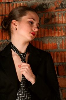 Girl In Black Suit Tuck Her Necktie. Stock Images