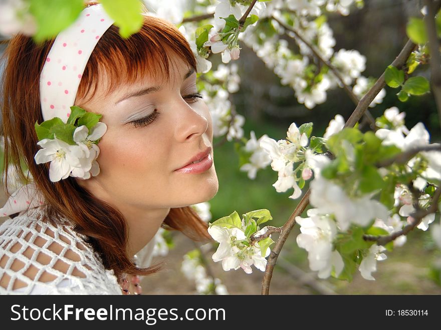 Beautiful young girl surrounded by branches of a flowering apple tree. Beautiful young girl surrounded by branches of a flowering apple tree